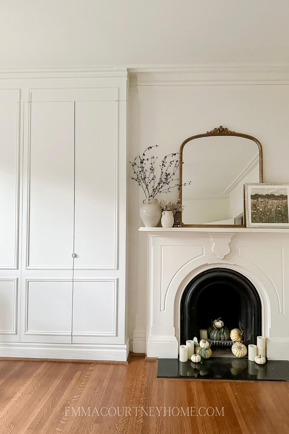 fireplace with fall decor and panelled wardrobe beside